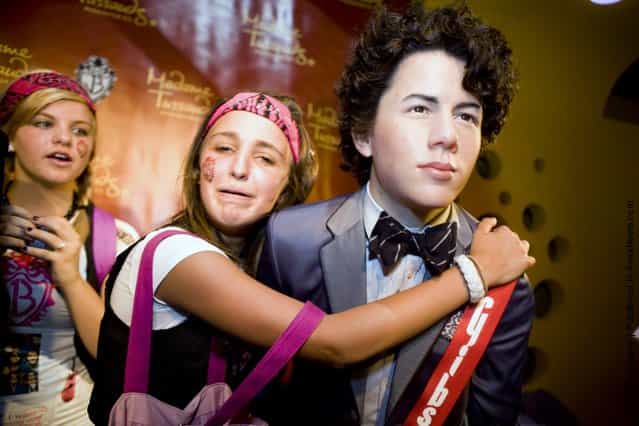 Maddy Pomilla, 14, from Huntingtown, MD, takes a picture of herself with a wax figure of Nick Jonas of the Jonas Brothers at Madame Tussauds