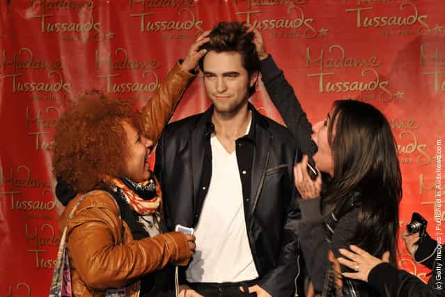Fans pose for photographs with the Robert Pattinson wax figure