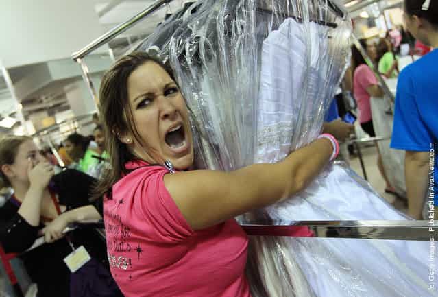 Bride to be Nicole Christos of Raleigh, North Carolina holds a rack of a wedding gowns while telling her mother that other gowns she has eyed were being taken, during Filene's Basement's annual sale