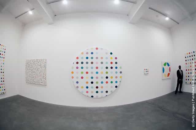 A security guard watches over the artist Damien Hirsts exhibition The Complete Spot Paintings, with the Cycloheximide, 2007