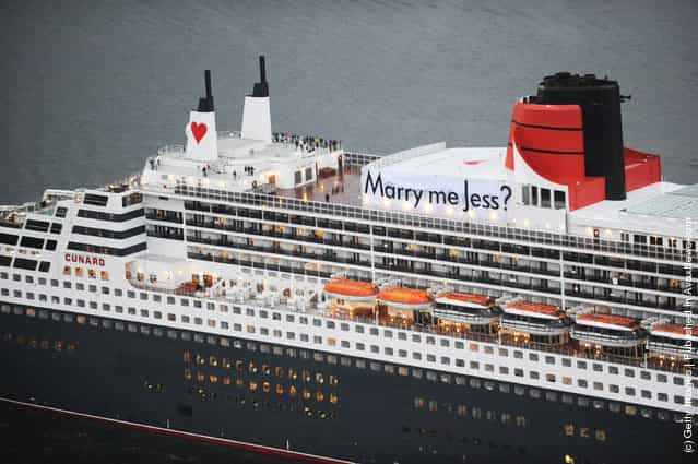 A banner with the message Marry Me Jess? hangs from the funnel of the Queen Mary 2 as it arrives into Sydney Harbour on Valentines day, February 14, 2012 in Sydney, Australia