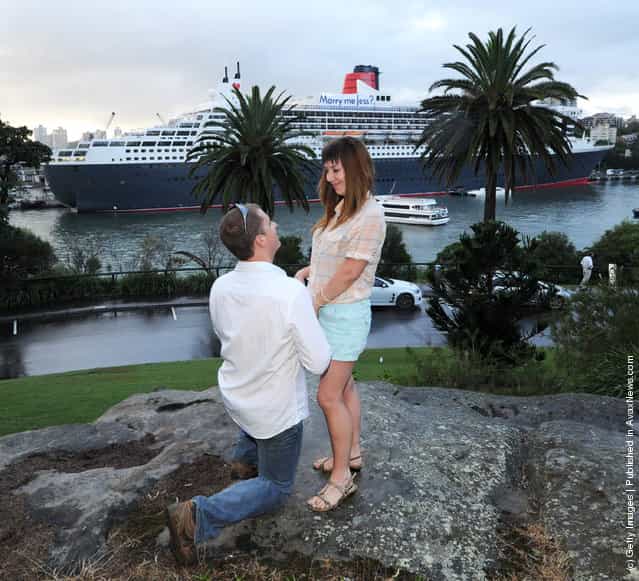 Stefan Libon proposes to girlfirend Jess McGarrity in front of a banner message Marry Me Jess? on the deck of the Queen Mary 2, at Mrs Macquaries Chair on Valentines day, February 14, 2012 in Sydney, Australia