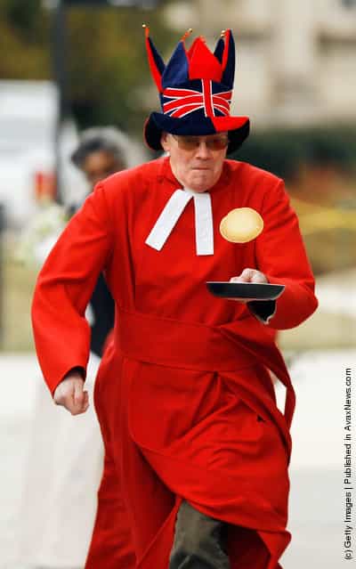 Canon Ralph Godsall, priest vicar at Westminster Abbey in London, participates in his first pancake race during the Shrove Tuesday, or Mardi Gras, tradition at the National Cathedral