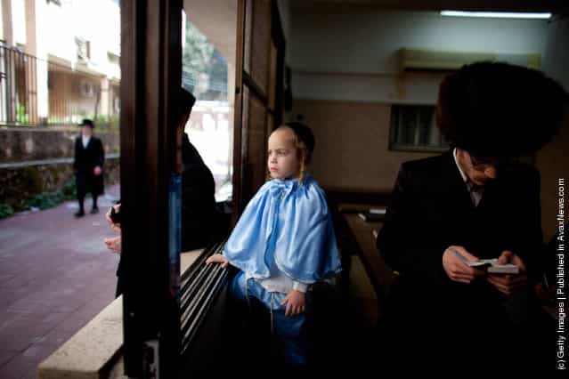 A boy looks out of a window as Ultra Orthodox Jews celebrate the Jewish holiday of Purim