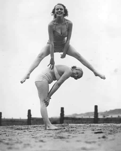 Two women enjoying a game of leap-frog on the beach at Blackpool. 28th March 1936.