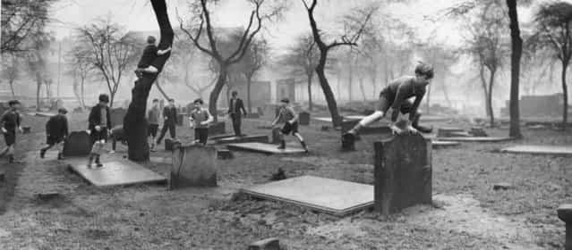 A group of boys from the Gorbals play amongst the gravestones of the Corporation Burial Ground in Rutherglen Road, UK, one of the few areas of greenery in the district, 1948. (Photo by Bert Hardy)