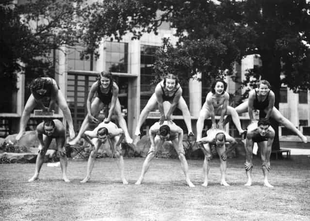 Women divers who are competing in the European Championships at Wembley, London playing leapfrog with the speedway riders as part of a [keep fit] regime. 6th July 1938. (Photo by George W. Hales)