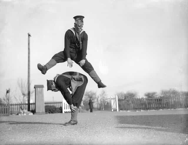 Able seamen at the Royal Navy Anti-Gas School at Tipnor, Portsmouth play leapfrog wearing gas masks, to accustom them to carrying out strenuous tasks in respirators. 22nd January 1934. (Photo by William Vanderson)