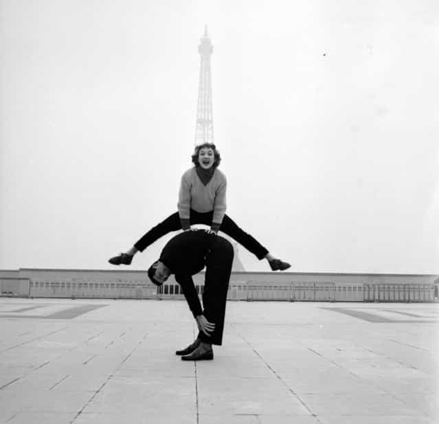 Paris street performers Jean Louis Bert and Grethe Bulow playing leap-frog in front of the Eiffel Tower, 1955. (Photo by Jean Berton)