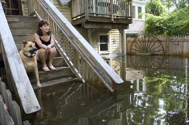 Patty Yardley and dog Bailey sit on the rear steps of their Ferry Street home and watch as floodwaters from the Delaware and Raritan Canal and Delaware River continue to rise June 29, 2006 in Lambertville, New Jersey