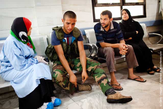 A Libyan Rebel soldier reacts after a fellow fighter