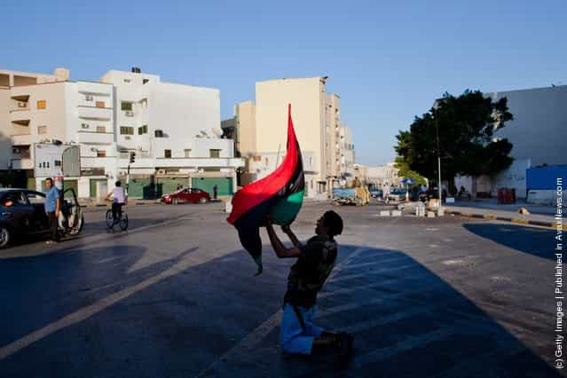 A Libyan Rebel fighter yells anti-Gaddafi slogans as he celebrates in the street