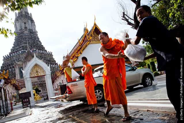 Thai monks unload sandbags to help fortify a temple from rising flood waters from the overflowing Chao Phraya river