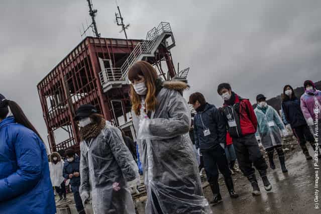 Students, volunteering to help clean the Shizukawa river from Kanto region, gather to their pay respects to tsunami victims at the site of the Minamisanriku Disaster Emergency Center headquarters now seen as a symbol of the tsunami, destroyed during last years tsunami on March 11, 2012 near Ishinomaki