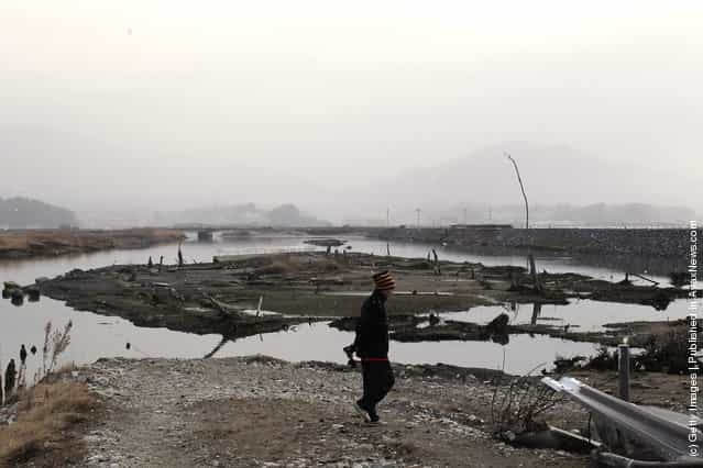 A man walks through a destroyed area near the seaside on March 11, 2012 in Rikuzentakata, Japan