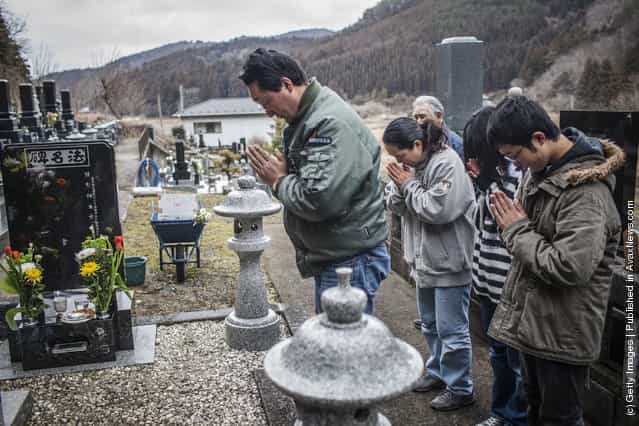 Takahiro Shito, 47, and his wife Sayomi Shito, 46, pray with their children Tomoka, 14, and Kenya 16, and their great uncle Akinori Takahashi, 76, as they pay respects to their daughter Chisato,12, buried in a nearby cemetery, victim of the Okowa Elementary School tragedy, who was killed during last years tsunami on March 11, 2012 near Ishinomaki, Japan