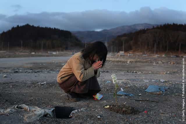 Keiko Suzuki, 40 prays at the site of her uncles home on March 11, 2012 in Rikuzentakata, Japan