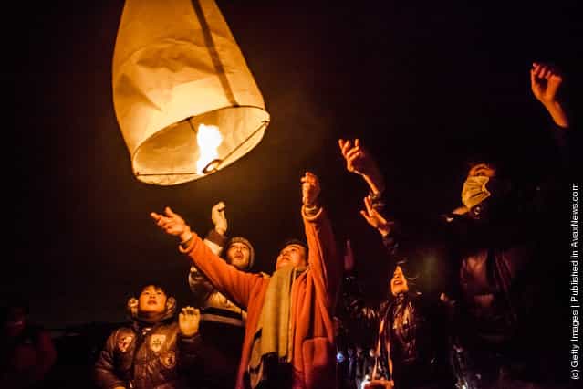 Families release a paper lantern into the sky in commemoration of the victims of last years earthquake and tsunami, on March 11, 2012 in Natori, Japan