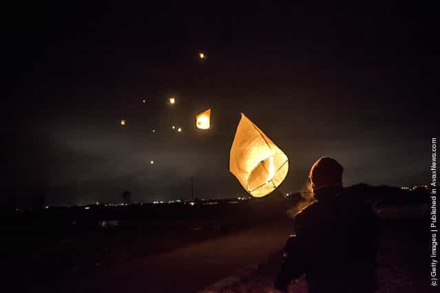 Families release a paper lantern into the sky in commemoration of the victims of last years earthquake and tsunami, on March 11, 2012 in Natori, Japan