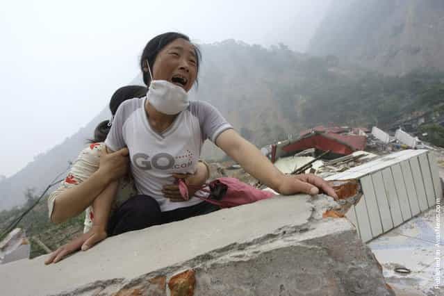 A woman cries as she cannot find her 4-year-old daughter and husband on the top of the ruins of a destroyed school in earthquake-hit Beichuan county, Sichuan province, May 17, 2008