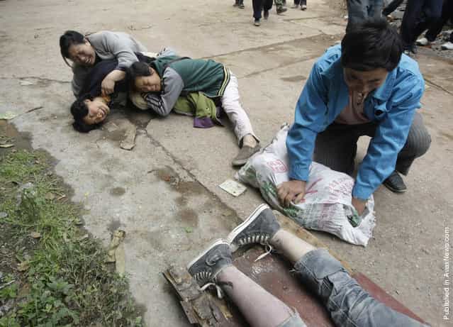 Relatives cry next to the recovered body of a student near a school at the earthquake-hit Hanwang Town of Mianzhu County, Sichuan province, May 14, 2008