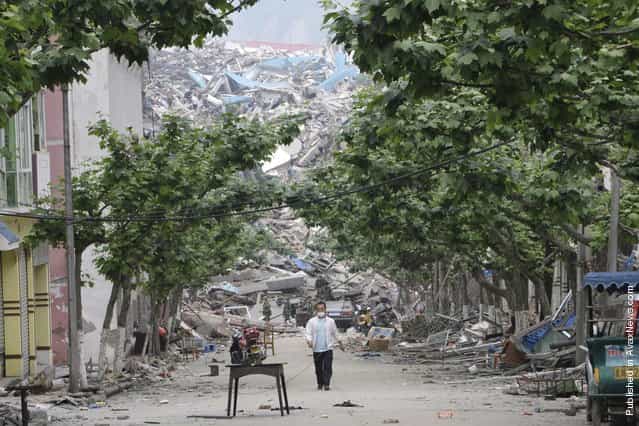 A local resident leaves the ruins of the destroyed old city district, near a mountain at the earthquake-hit Beichuan county, Sichuan province