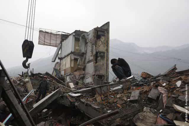 A man cries next to a rescue worker on the roofs of destroyed houses after an earthquake, in Hanwang town in Mianzhu, located around 83 km (50 miles) north of Chengdu, May 13, 2008