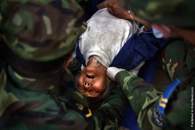 A Chinese earthquake survivor is lifted by Chinese soldiers in the town of Mianzhu in China’s southwest Sichuan province to be taken by ambulance to another city for treatment May 24, 2008