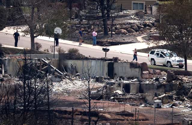 Policemen stand guard near residents who were temporarily allowed to visit their homes destroyed by the Waldo Canyon fire in the Mountain Shadows neighborhood of Colorado Springs, on July 1, 2012. (Reuters/Adrees Latif)