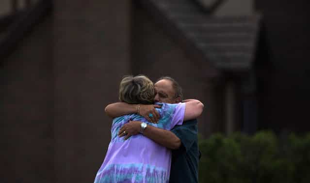 Neighbors, who evacuated their homes from the encroaching Waldo Canyon fire, embrace after returning to their homes in Colorado Springs,on July 1, 2012. Residents began returning to charred areas of Colorado Springs on Sunday after the most destructive wildfire in Colorado history forced tens of thousands of people from their homes and left the landscape a blackened wasteland. The neighbors wished to stay unidentified due to "jealous spouses," they said. (Reuters/Adrees Latif)