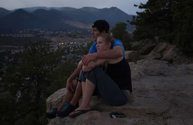 Residents Lindsay Hetzel and Nathan Birdseye sit on a cliff overlooking the Waldo Canyon fire in Colorado Springs, on June 30, 2012. Crews battling a deadly Colorado wildfire ranked the most destructive in state history have made enough headway to allow most evacuees home, but concerns remain about rogue bears and burglaries in vacant houses, officials said. (Reuters/Adrees Latif)