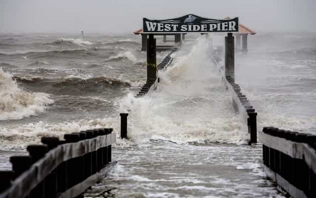 Water washes over a pier in Gulfport, Mississippi on Wednesday. Hurricane Isaac hovered over the Gulf Coast during the morning, punishing southeast Louisiana with 80 mph wind gusts, horizontal rain and the threat of calamitous flooding. (Photo by Brendan Hoffman/The New York Times)