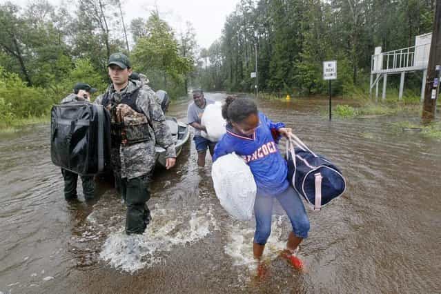 A family in Pearlington, Miss., is helped to dry land on Aug. 29. (Photo by Rogelio V. Solis/AP)