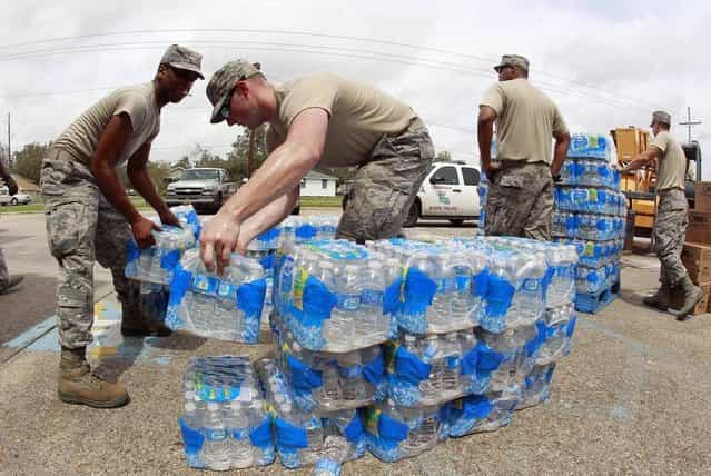 Members of the Louisiana Air National Guard work to distribute water and prepackaged food to victims of Hurricane Isaac on Aug. 31 in Belle Chasse, La. Isaac sloshed north into the central U.S. after flooding stretches of Louisiana and Mississippi and knocking out power, leaving entire water-logged neighborhoods without lights, air conditioning or clean water. (Photo by John Bazemore/AP)