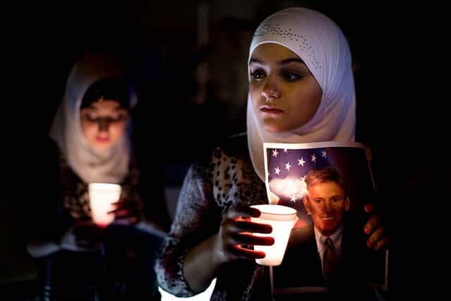 Dilan Samo, 13, holds a picture of slain U.S. ambassador to Libya Christopher Stevens during a candlelight vigil outside the Libyan Embassy in New York. (Photo by John Minchillo/Associated Press)