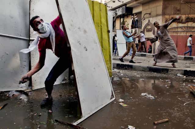 Protesters clash with security forces near the U.S. Embassy in Cairo, Egypt. (Photo by Khalil Hamra/Associated Press)