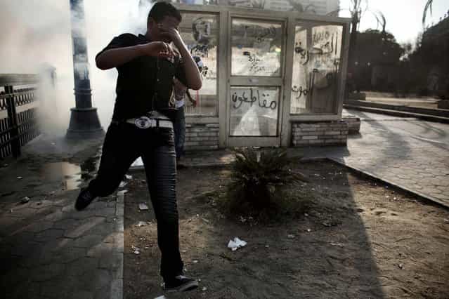 A protester runs from tear gas fired by police in Cairo. (Photo by Tara Todras-Whitehill/The New York Times)