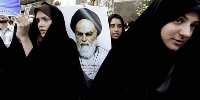 A protester holds a poster of the late revolutionary founder Ayatollah Khomeini during a demonstration against the film ridiculing Islam's Prophet Muhammad, in front of the Swiss Embassy in Tehran, which represents U.S. interests in Iran. (Photo by Vahid Salemi/Associated Press)
