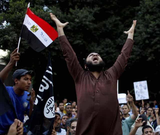 Protesters carry their national flag and a flag with Arabic that reads [No God but Allah, and Muhammad is his prophet], and chant anti-U.S. slogans during a demonstration in front of the U.S. embassy in Cairo, Egypt, as part of widespread anger across the Muslim world about a film ridiculing Islam's Prophet Muhammad. (Photo by Nasser Nasser/Associated Press)