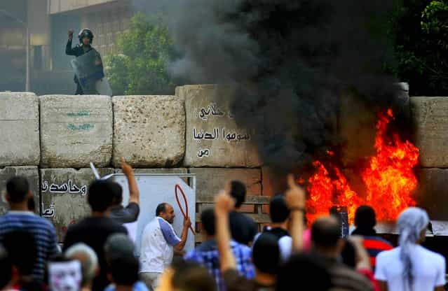 Protesters clash with security forces near the U.S. Embassy in Cairo, Egypt. (Photo by Khalil Hamra/Associated Press)