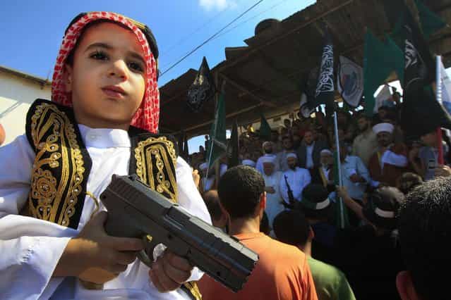 A boy holds a toy gun during a protest about a film ridiculing Islam's Prophet Muhammad in the Palestinian refugee camp of Ain el-Hilweh near Sidon, Lebanon, September 14, 2012. (Photo by Mohammed Zaatari/Associated Press)