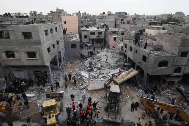 Palestinians gather at the site of an Israeli air raid in Gaza City on November 17, 2012. Israeli air strikes hit the cabinet headquarters of Gaza's Hamas government after militants fired rockets at Jerusalem and Tel Aviv as Israel called up thousands more reservists in readiness for a potential ground war.(Photo by Mohammed Abed/AFP Photo)