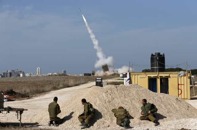 Israeli soldiers watch as an Iron Dome launcher fires an interceptor rocket near the southern city of Ashdod November 18, 2012. Israel bombed Palestinian militant targets in the Gaza Strip from air and sea for a fifth straight day on Sunday, preparing for a possible ground invasion though Egypt saw [some indications] of a truce ahead. (Photo by Darren Whiteside/Reuters)