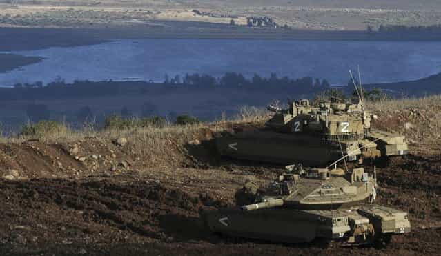 Israeli tanks stand in position overlooking a Syrian village from the Israeli-occupied Golan Heights, November 12, 2012. (Photo by IDF)