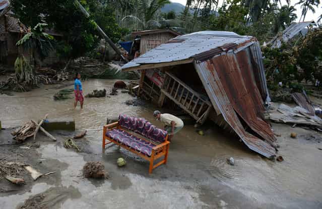 Residents clean their sofa next to their damaged house in New Bataan town, Compostela Valley province, a day after Typhoon Bopha hit the province. At least 274 people have been killed and hundreds remain missing in the Philippines from the deadliest typhoon to hit the country this year, the civil defense chief said December 5, 2012. (Photo by Ted Aljibe)