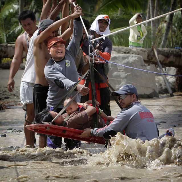 Rescuers evacuate a pregnant woman with her child after surviving flooding in New Bataan town, Compostela Valley, southern Philippines. Rescuers found a six-months pregnant women from the other side of a river with her one-year-old son after escaping floods that swamped their house after Typhoon Bopha hit land on Tuesday in Compostela Valley. The death toll has risen to 332 on Thursday with hundreds missing, disaster officials said. (Photo by Erik De Castro/Reuters photo)