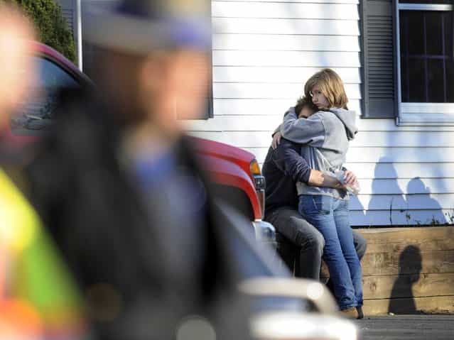 People embrace at a firehouse staging area near the scene of the shootings. (Photo by Jessica Hill/Associated Press)