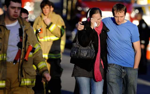 A victim's family leaves a firehouse staging area following the shooting. (Photo by Jessica Hill/Associated Press)