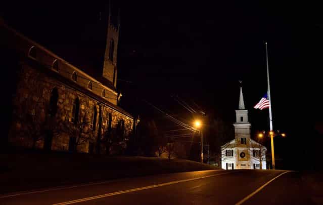 A U.S. flag flies at half-staff on Main Street in Newtown. (Photo by David Goldman/Associated Press)