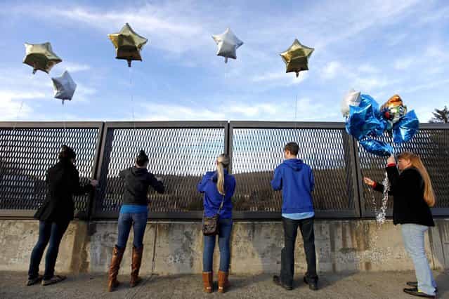 Suada Likovic, Chelsea Crain, Kristin Hoyt, Jeffrey Hoyt and Linda Hoyt, all of Danbury, tie balloons to an overpass up the road from the Sandy Hook Elementary School. (Photo by David Goldman/Associated Press)